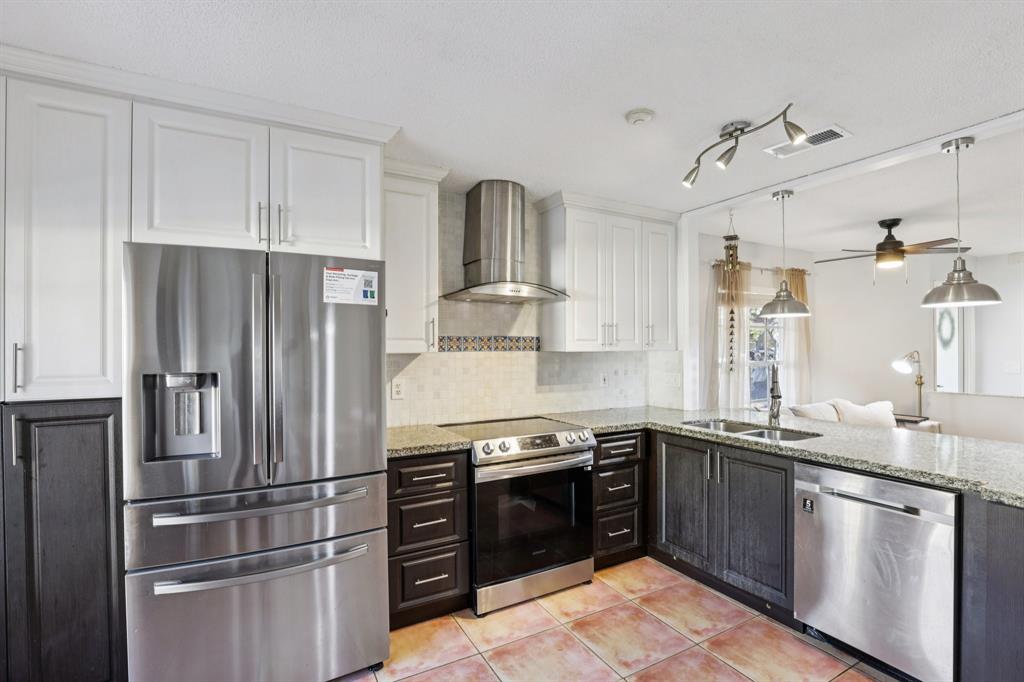 972 Azure Lane Weston, FL 33326 - Photo 14 of 61 a kitchen with stainless steel appliances granite countertop a stove a refrigerator and a sink