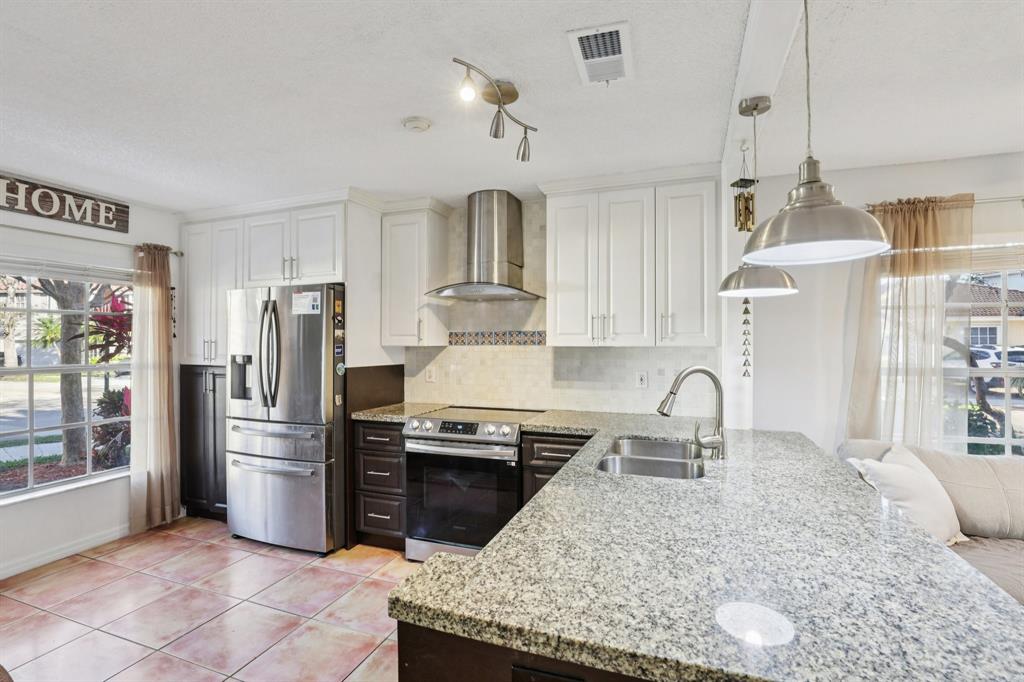 972 Azure Lane Weston, FL 33326 - Photo 15 of 61 a kitchen with stainless steel appliances granite countertop a sink stove and refrigerator