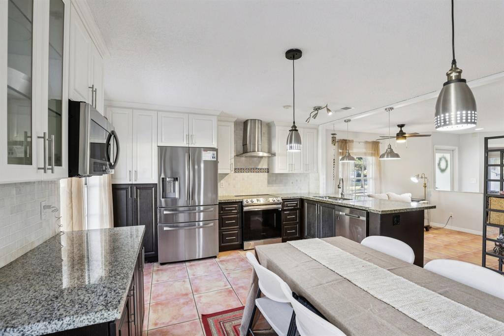 972 Azure Lane Weston, FL 33326 - Photo 17 of 61 a open kitchen with stainless steel appliances granite countertop a stove refrigerator and cabinets