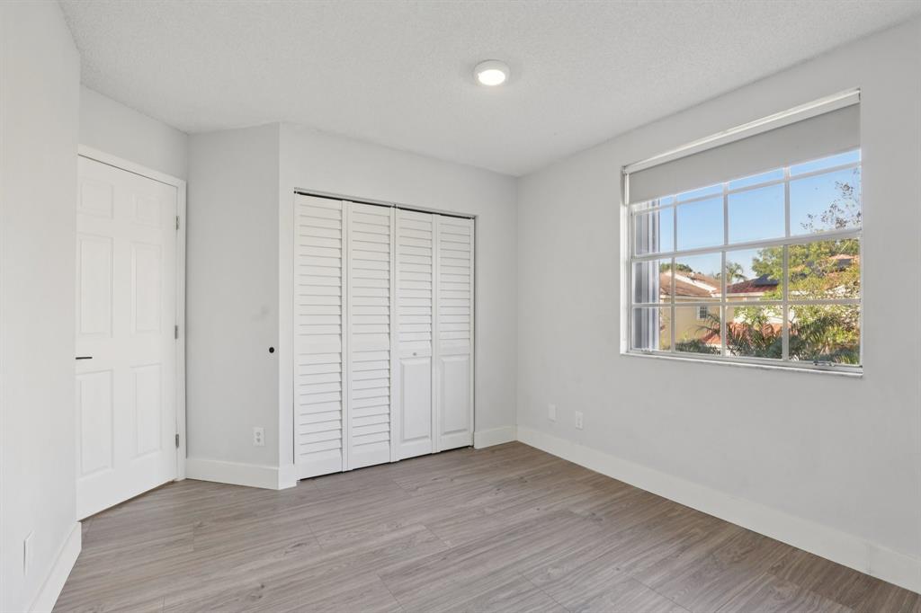 972 Azure Lane Weston, FL 33326 - Photo 36 of 61 an empty room with wooden floor closet and windows