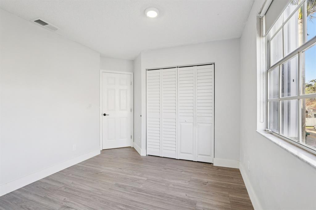 972 Azure Lane Weston, FL 33326 - Photo 37 of 61 an empty room with wooden floor and windows