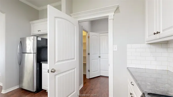 a view of hallway with cabinets and wooden floor