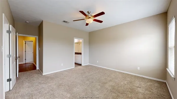 an empty room with closet and ceiling fan