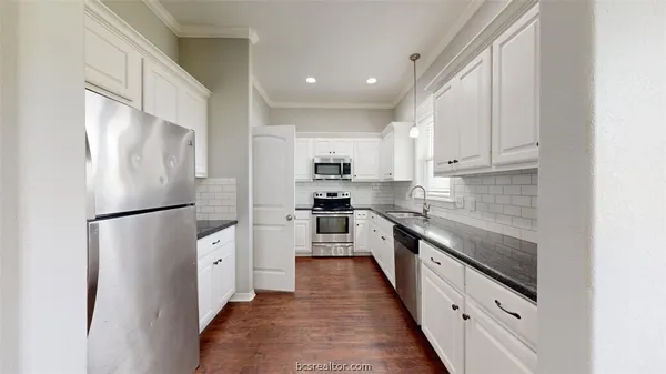 a kitchen with stainless steel appliances a refrigerator sink and cabinets