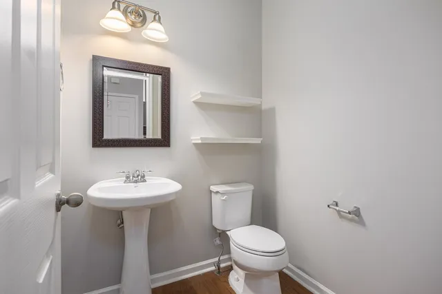 a bathroom with a toilet sink and mirror