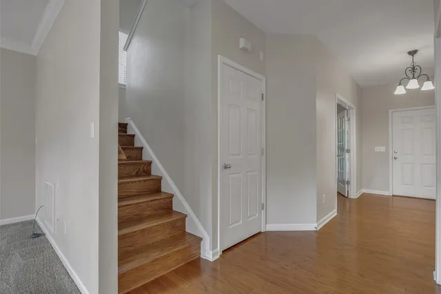 a view of a hallway with wooden floor and entryway