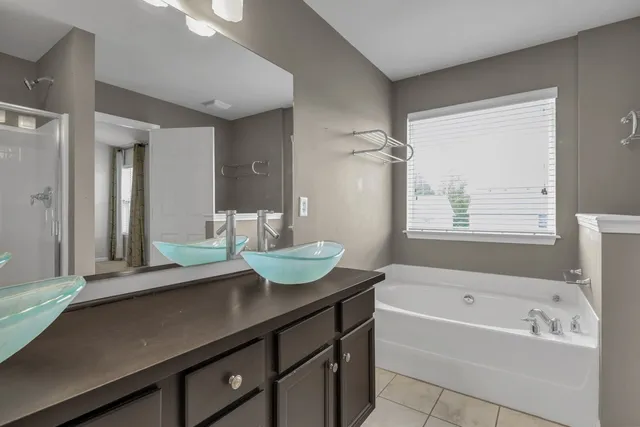 a bathroom with a granite countertop sink mirror and a bathtub