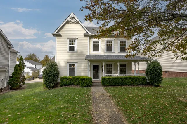 a front view of a house with a yard and trees