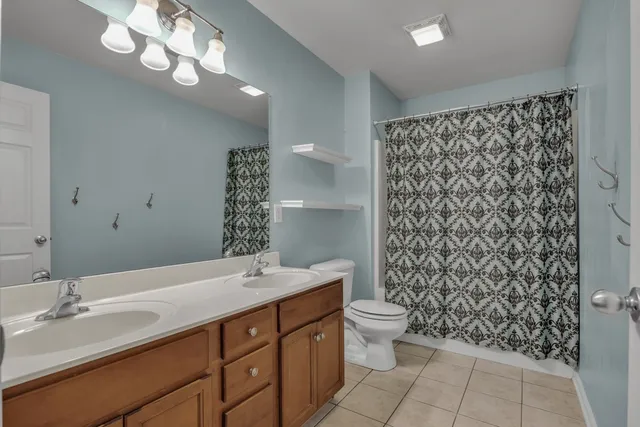 a bathroom with a double vanity sink mirror and toilet