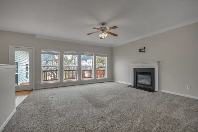 a view of an empty room with a fireplace and a window