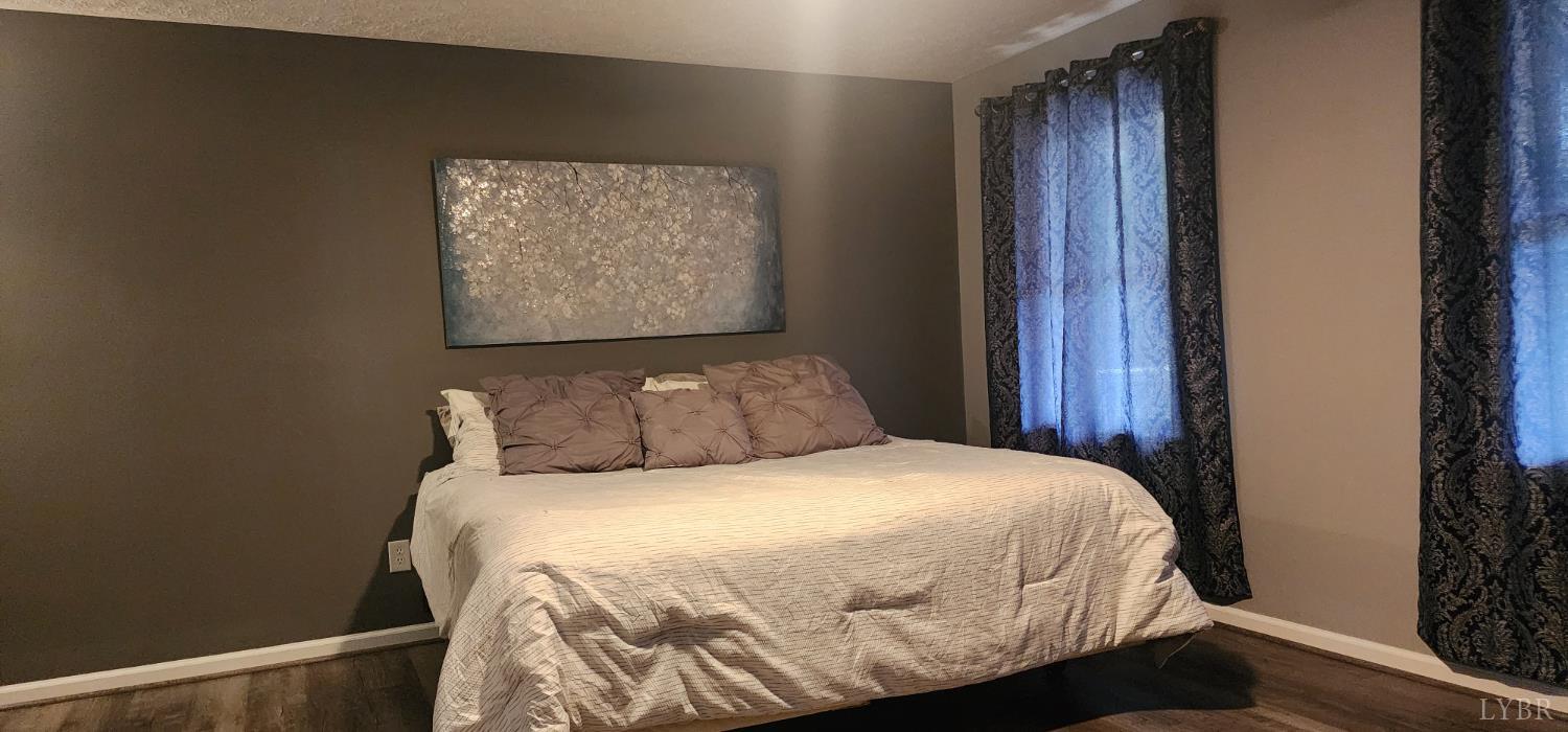 297 Poor House Farm Road Amherst, VA 24521 - Photo 18 of 52 a bed sitting in a bedroom next to a wooden door