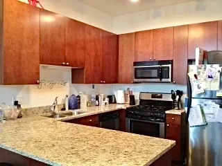 a kitchen with stainless steel appliances wooden cabinets a stove top oven a sink and dishwasher
