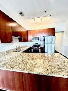 a view of a kitchen with wooden cabinet