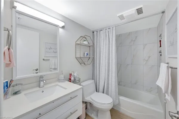 a bathroom with a shower sink vanity mirror and toilet