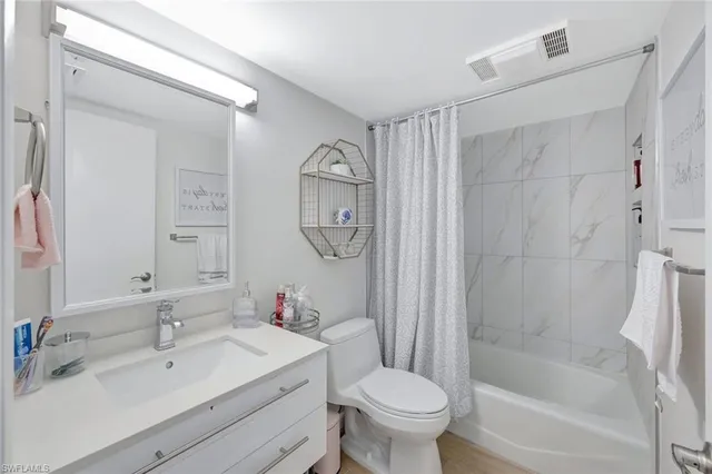 a bathroom with a shower sink vanity mirror and toilet