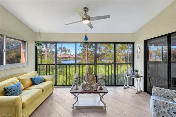 a living room with furniture and floor to ceiling windows