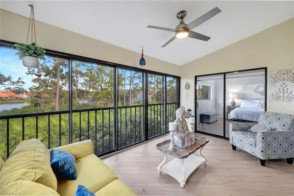 a living room with furniture large window and ceiling fan