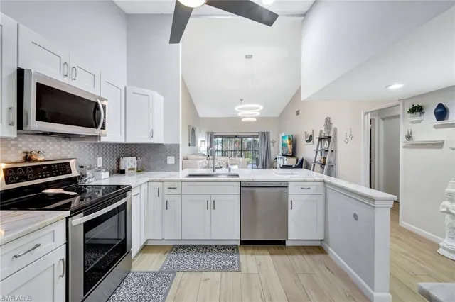 a kitchen with white cabinets stainless steel appliances and sink
