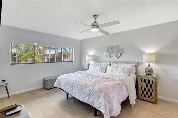 a bedroom with a bed and painting on the wall