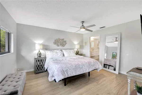 a bedroom with a large bed and a chandelier