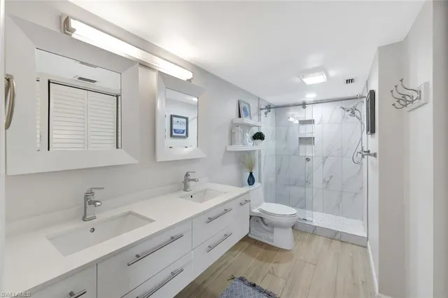 a bathroom with a double vanity sink mirror and toilet