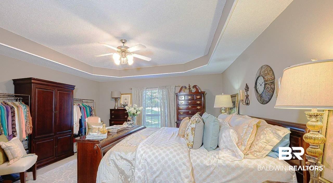 12230 Bromley Road Stapleton, AL 36578 - Photo 19 of 34 Bedroom with light carpet, a tray ceiling, a ceiling fan, and a textured ceiling