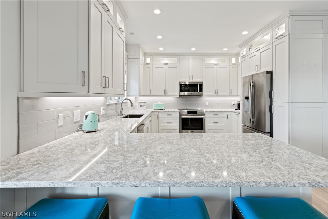 5294 Umbrella Pool Road Sanibel, FL 33957 - Photo 13 of 44 a kitchen with stainless steel appliances granite countertop a sink a stove and a refrigerator
