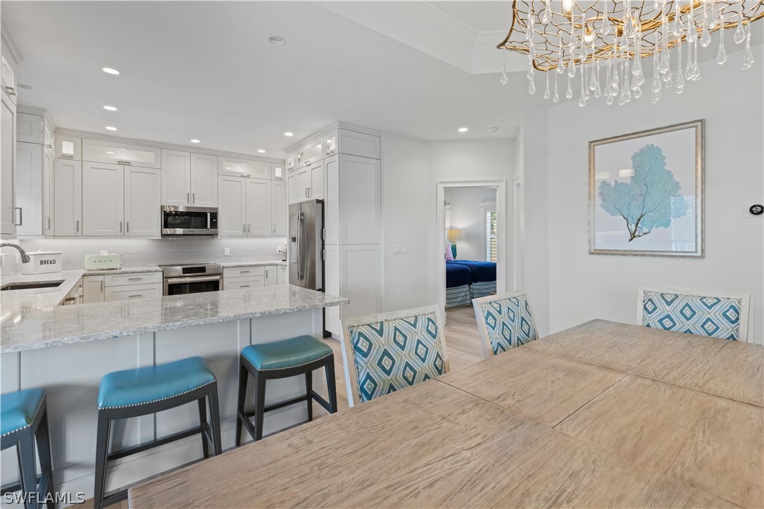 5294 Umbrella Pool Road Sanibel, FL 33957 - Photo 16 of 44 a kitchen with granite countertop a refrigerator and a dining table