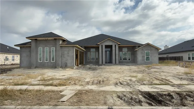a big house with wooden fence and trees in the background