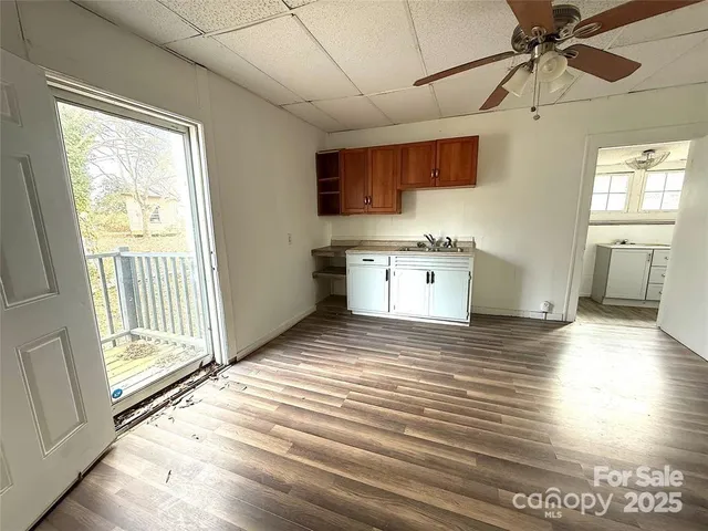a view of a kitchen with a stove cabinets wooden floor and a ceiling fan