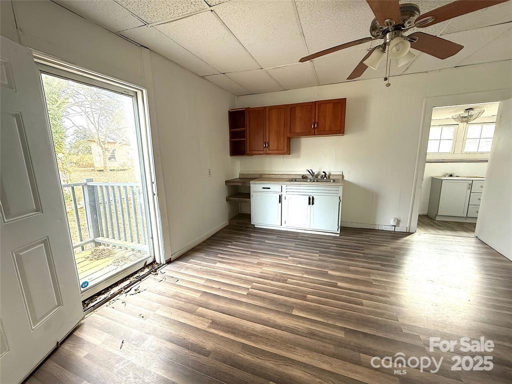 309 Spring Street Union, SC 29379 - Photo 5 of 11 a view of a kitchen with a stove cabinets wooden floor and a ceiling fan