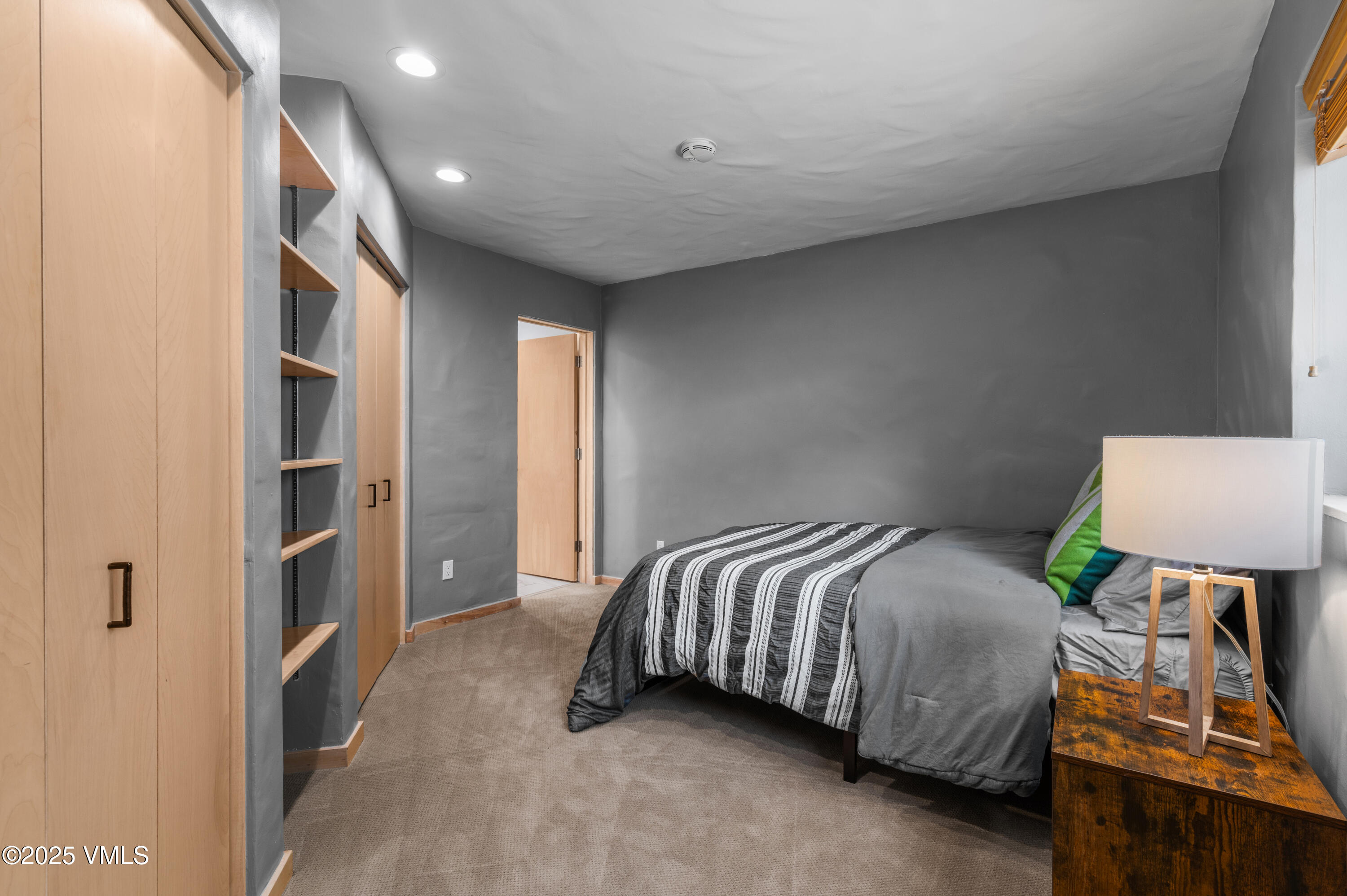 2349 Chamonix Lane Vail, CO 81657 - Photo 29 of 43 a bedroom with a bed and a lamp on dresser