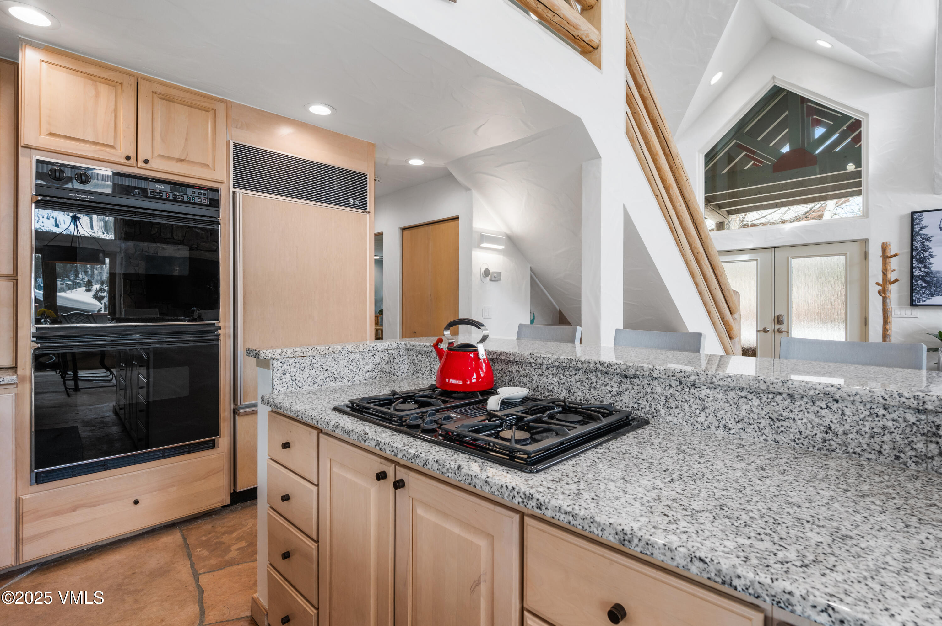 2349 Chamonix Lane Vail, CO 81657 - Photo 8 of 43 a kitchen with granite countertop a stove a sink and a microwave