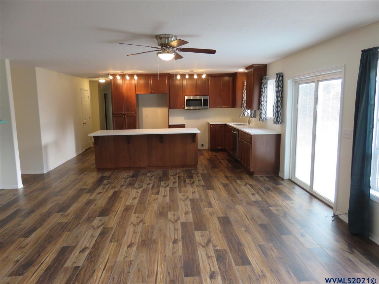 18990 Falls City Road Dallas, OR 97338 - Photo 6 of 42 a large kitchen with kitchen island white cabinets and stainless steel appliances