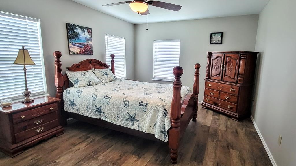 619 Copano Cove Road Rockport, TX 78382 - Photo 14 of 32 a bedroom with a bed and a chandelier