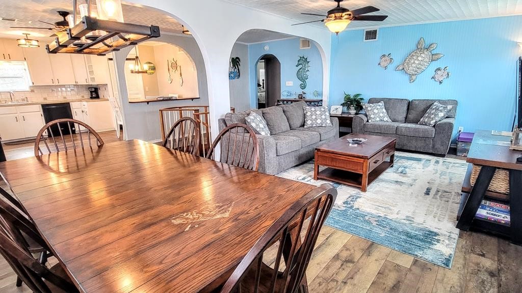 619 Copano Cove Road Rockport, TX 78382 - Photo 10 of 32 a living room with couches chairs and kitchen view with wooden floor