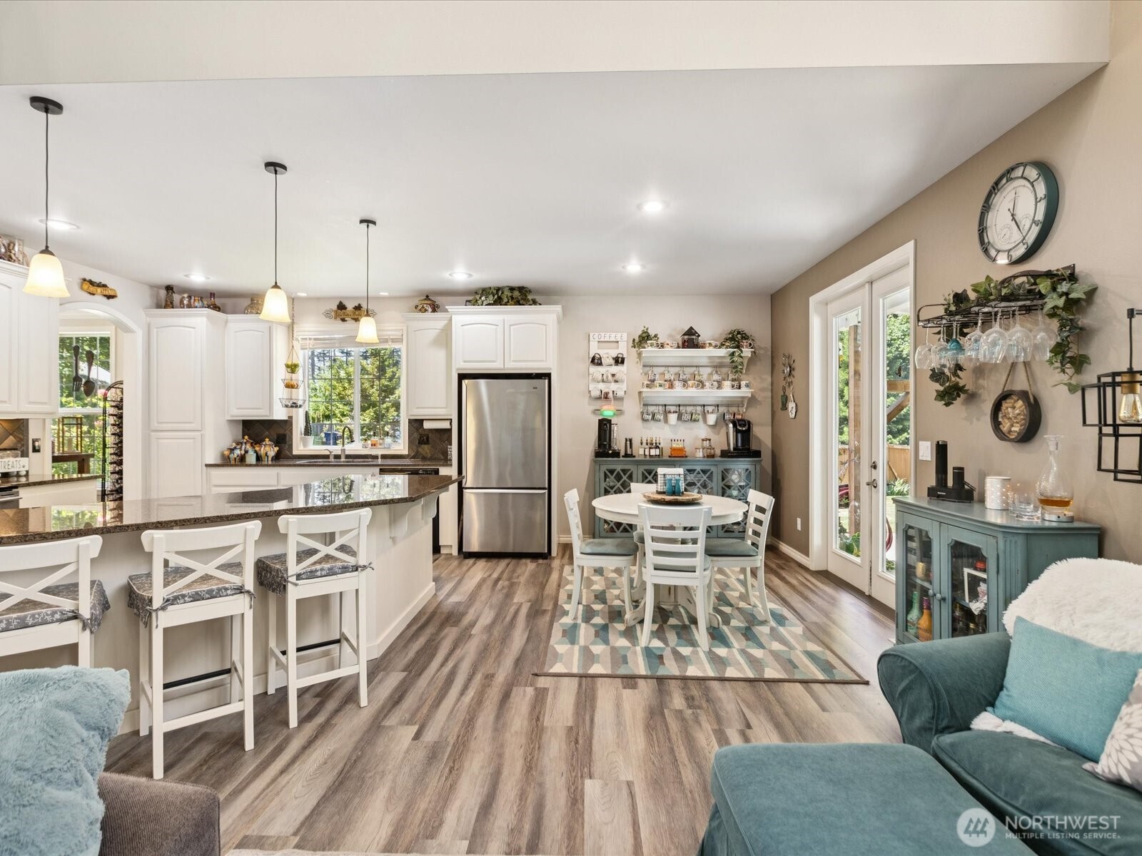 8817 Lakewood Road Stanwood, WA 98292 - Photo 17 of 40 a kitchen with stainless steel appliances a stove a refrigerator a dining table and chairs with wooden floor