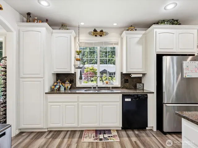 a kitchen with a refrigerator and white cabinets