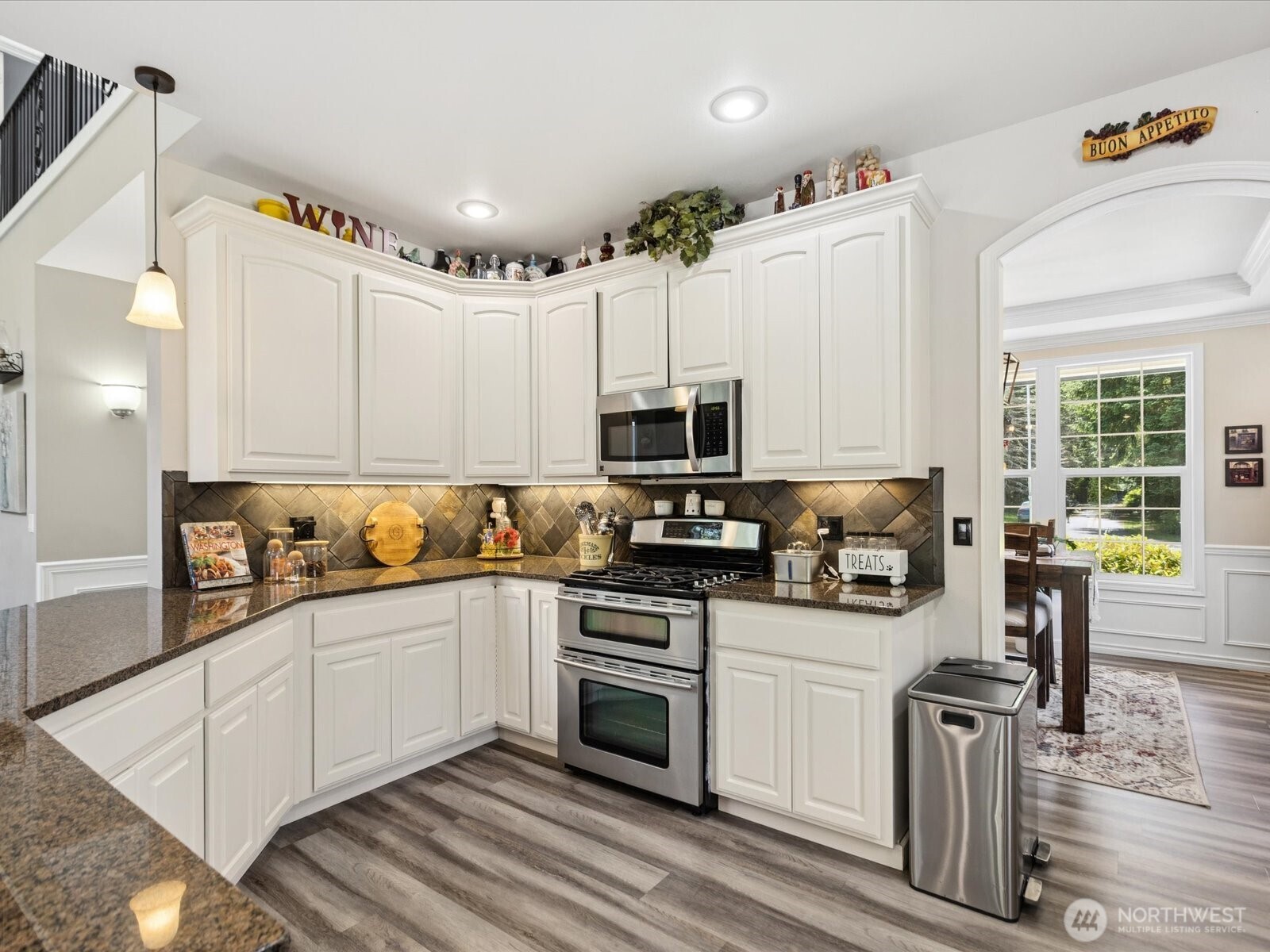8817 Lakewood Road Stanwood, WA 98292 - Photo 10 of 40 a kitchen with stainless steel appliances white cabinets a sink a stove a microwave and wooden floors