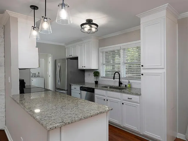 a kitchen with stainless steel appliances granite countertop a sink refrigerator stove and microwave