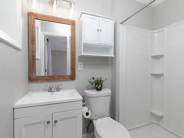 a bathroom with a sink a toilet and shower