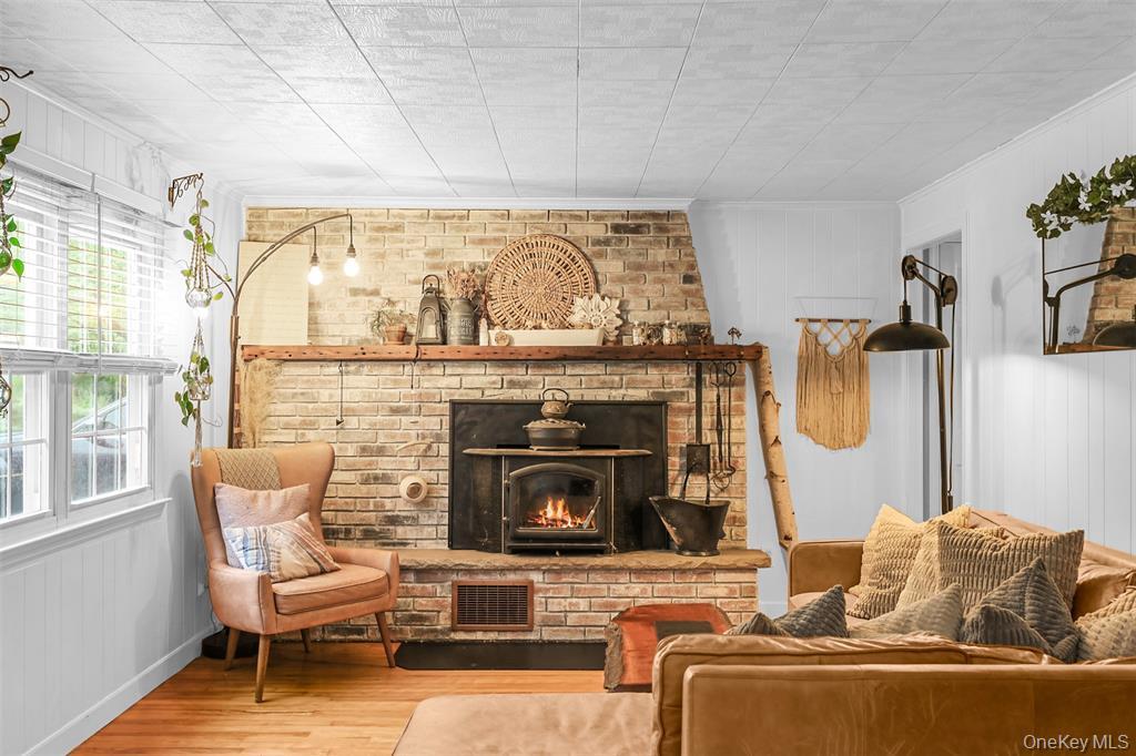 46 Quaker Hill Road Monroe, NY 10950 - Photo 12 of 33 Sitting room featuring wood walls, a brick fireplace, wood finished floors, and ornamental molding