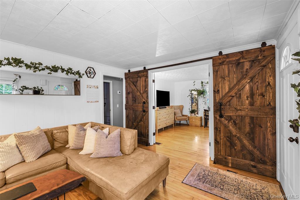 46 Quaker Hill Road Monroe, NY 10950 - Photo 14 of 33 Living area featuring a barn door, light wood finished floors, and crown molding