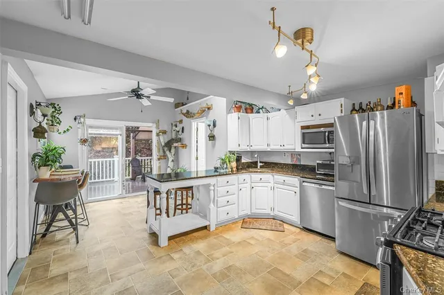 a kitchen with stainless steel appliances granite countertop a stove refrigerator and cabinets