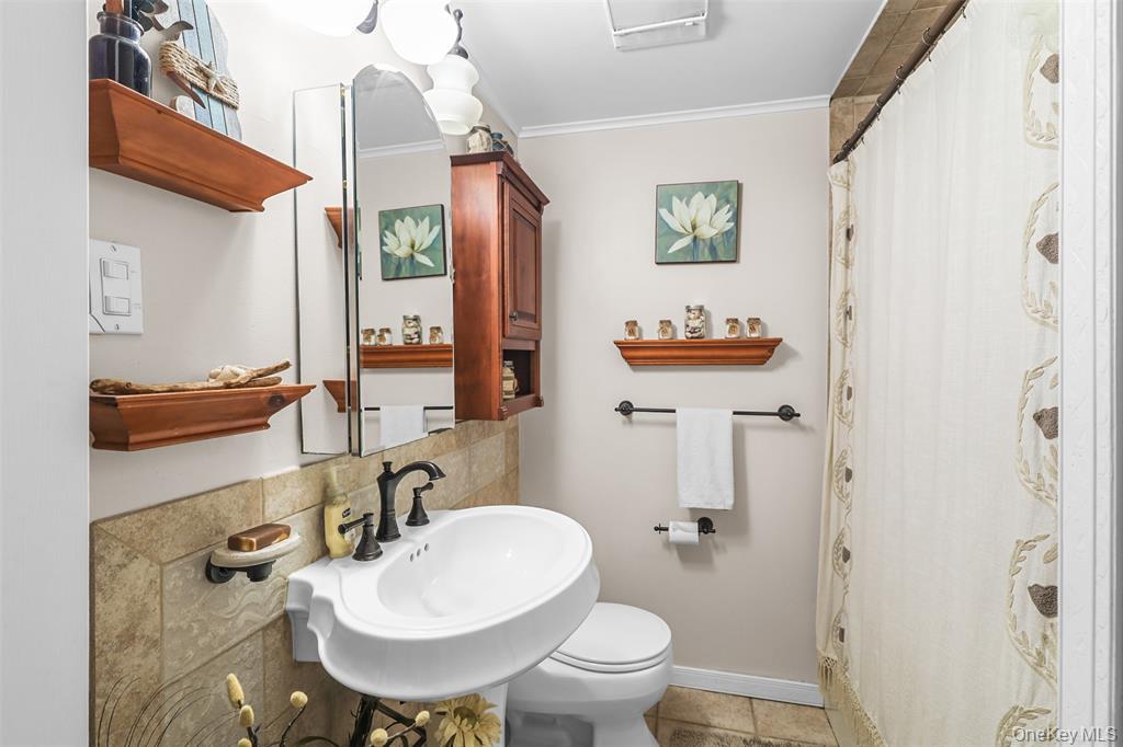 46 Quaker Hill Road Monroe, NY 10950 - Photo 23 of 33 Bathroom with crown molding, a shower with shower curtain, decorative backsplash, and light tile patterned floors