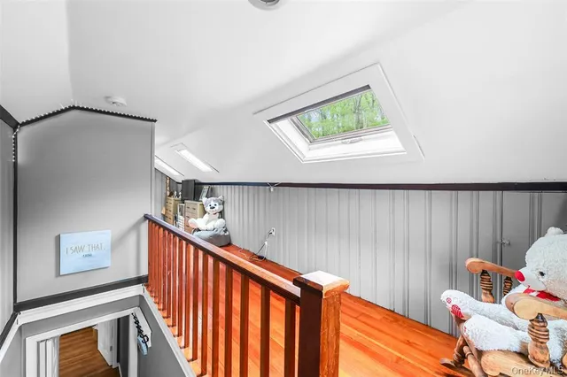 a view of a hallway to a livingroom with furniture and window