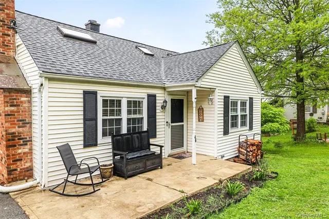 a view of a house with backyard and sitting area
