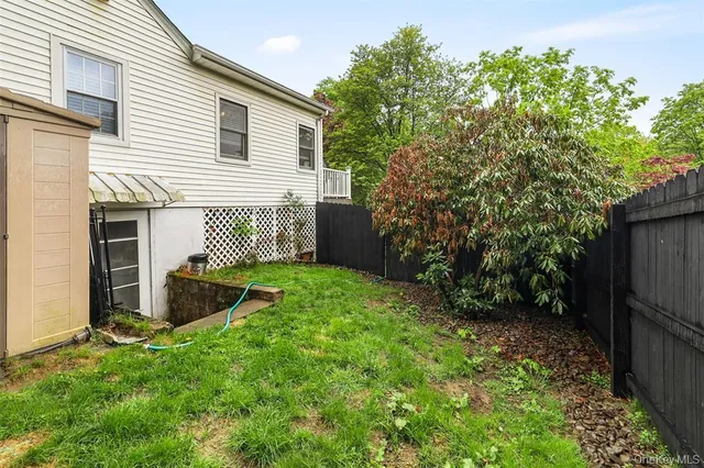 a view of a backyard with couches plants and large tree
