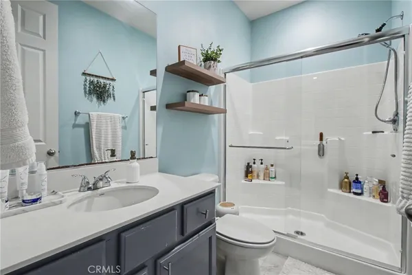 a bathroom with a granite countertop sink a toilet and shower
