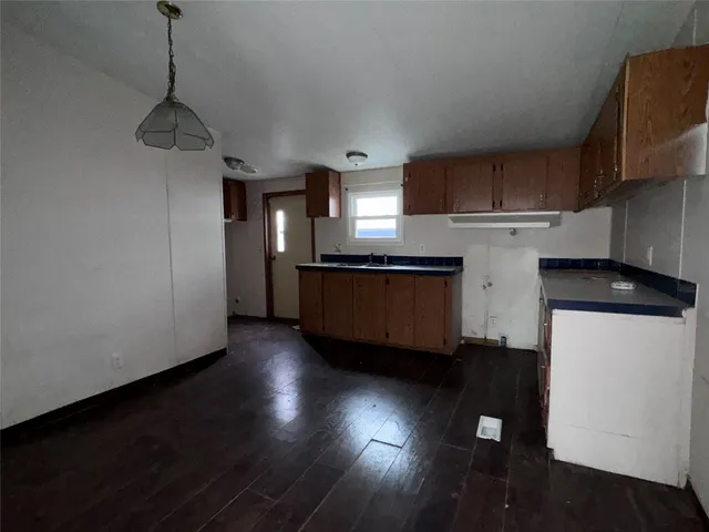 a kitchen with stainless steel appliances granite countertop a refrigerator a stove and a wooden floors